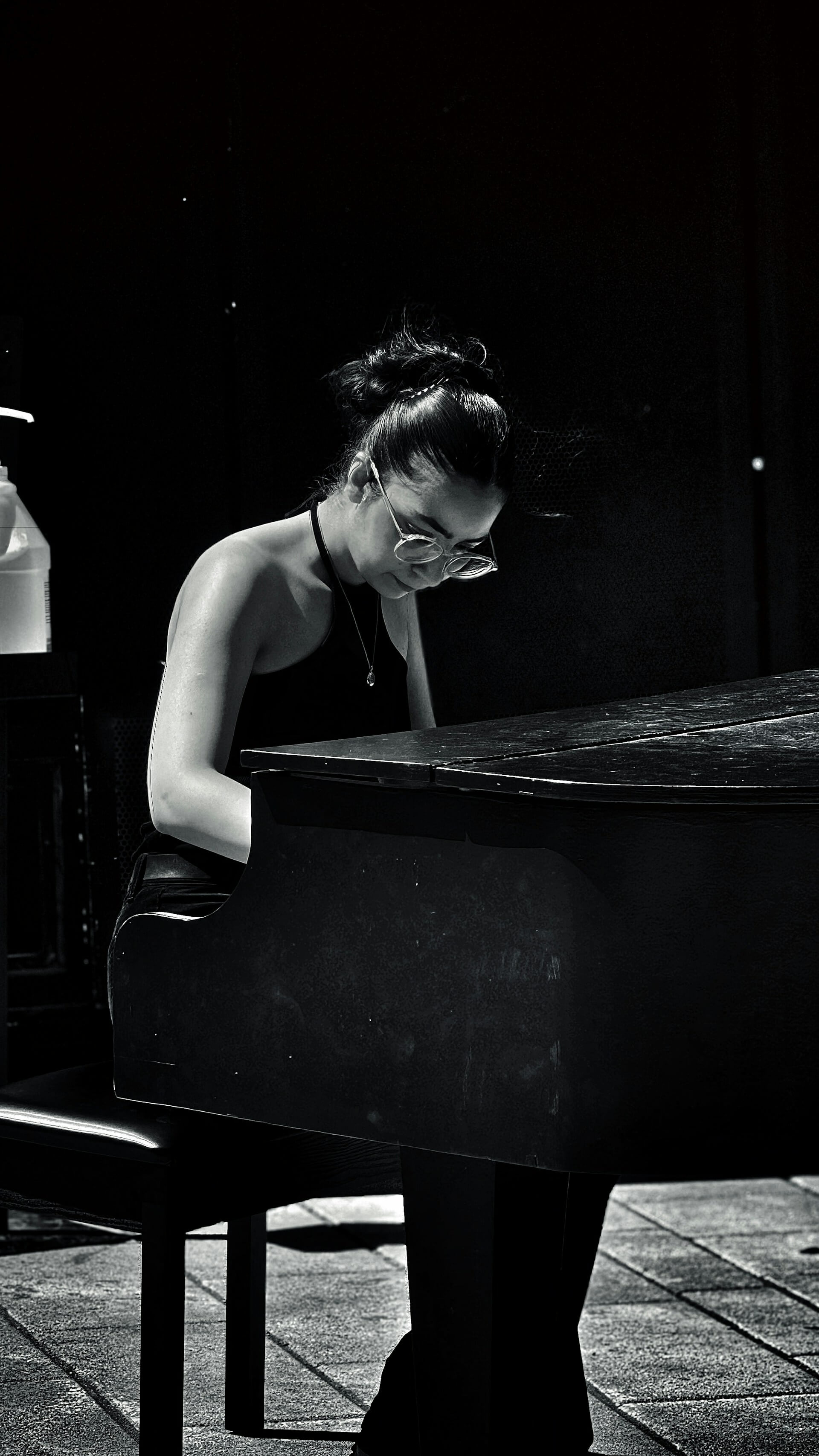 Black and white image of a girl playing the piano.