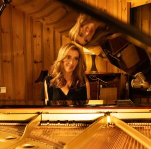 Konsertpianist sittandes vid ett piano.
